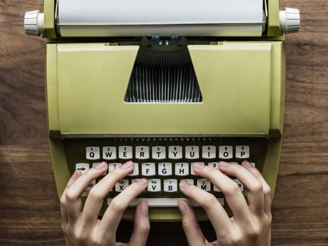 Aerial view of a man typing on a retro typewriter